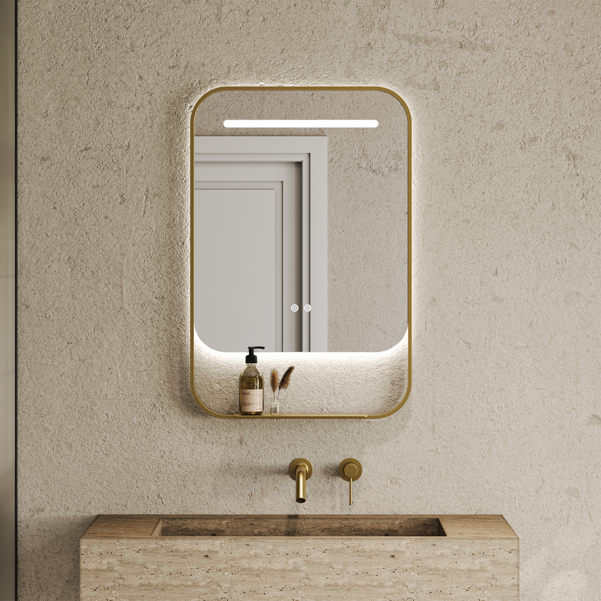Rectangular brushed gold framed mirror with a backlit LED strip and shelf above a stone basin