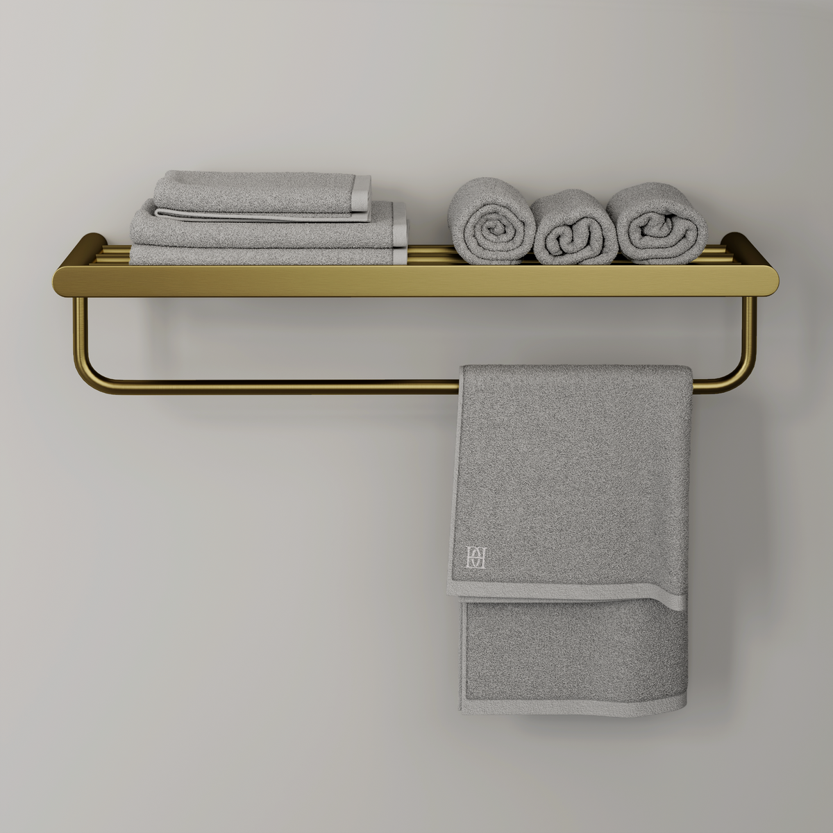 Brushed gold slatted wall shelf with towel rail beneath, holding folded and rolled grey towels and one hanging towel
