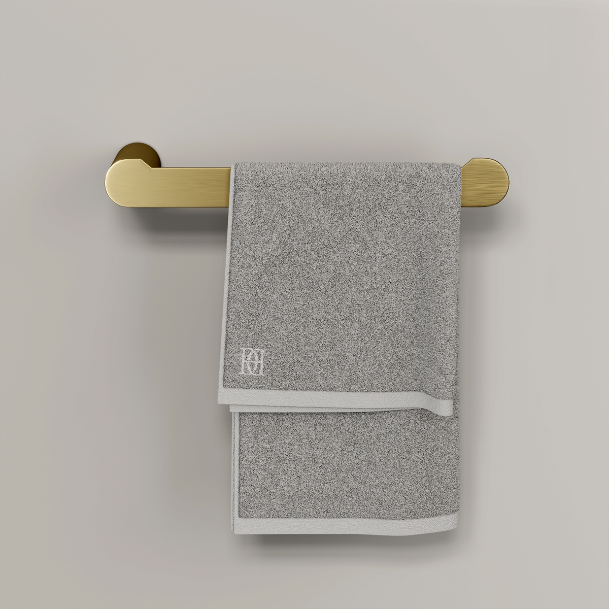 Brushed gold towel bar fixed to a wall with a folded grey towel hanging over it